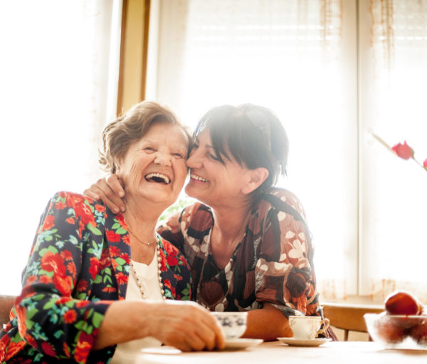 Senior Woman Enjoying a relaxing moment with her Daughter at Home drinking Coffee