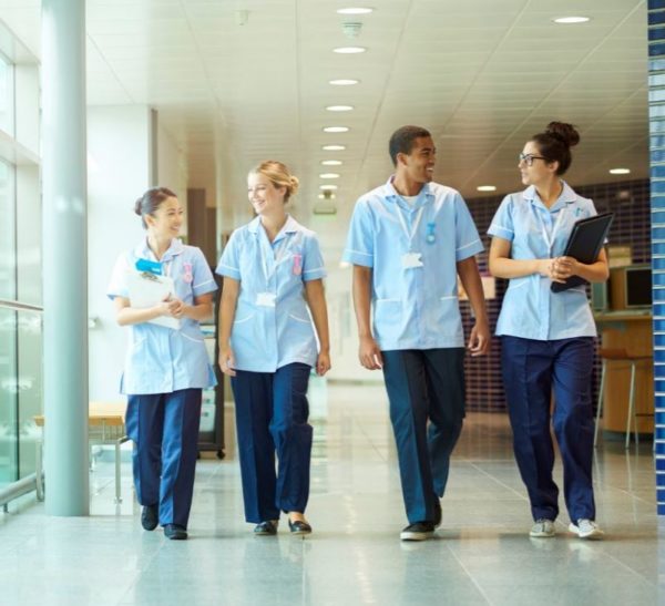group of nurses walking down hallway of rehabilitation facility