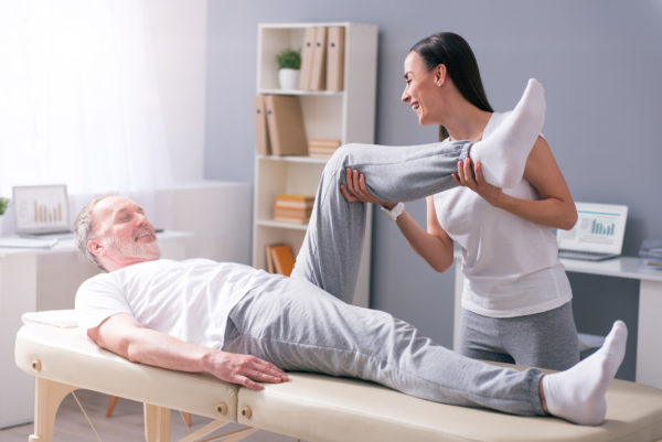 physical therapists working with elderly male patient