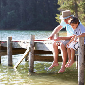 grandfather and grandson fishing off pier