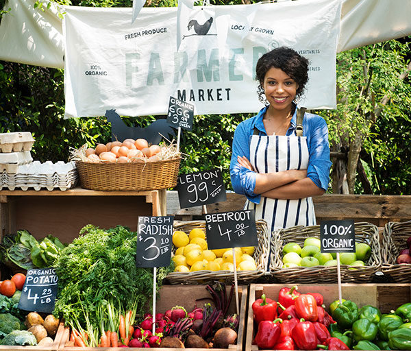 female vendor standing at a farmers market