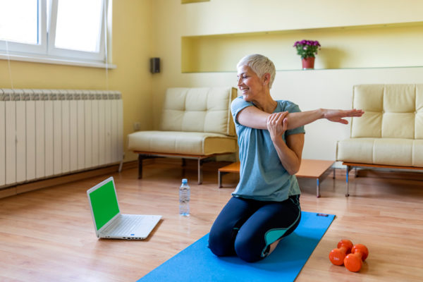 Senior woman doing yoga in living room