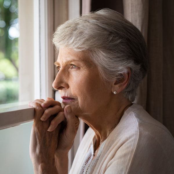 Elderly woman looking out window