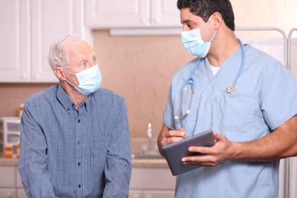 Nurse and patient wearing masks and talking