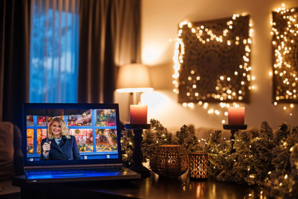 Woman on tv screen in room decorated for Christmas