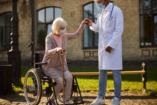 Patient in wheelchair with Doctor in park.