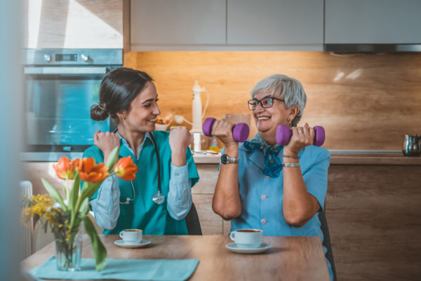 Two women working with hand weights